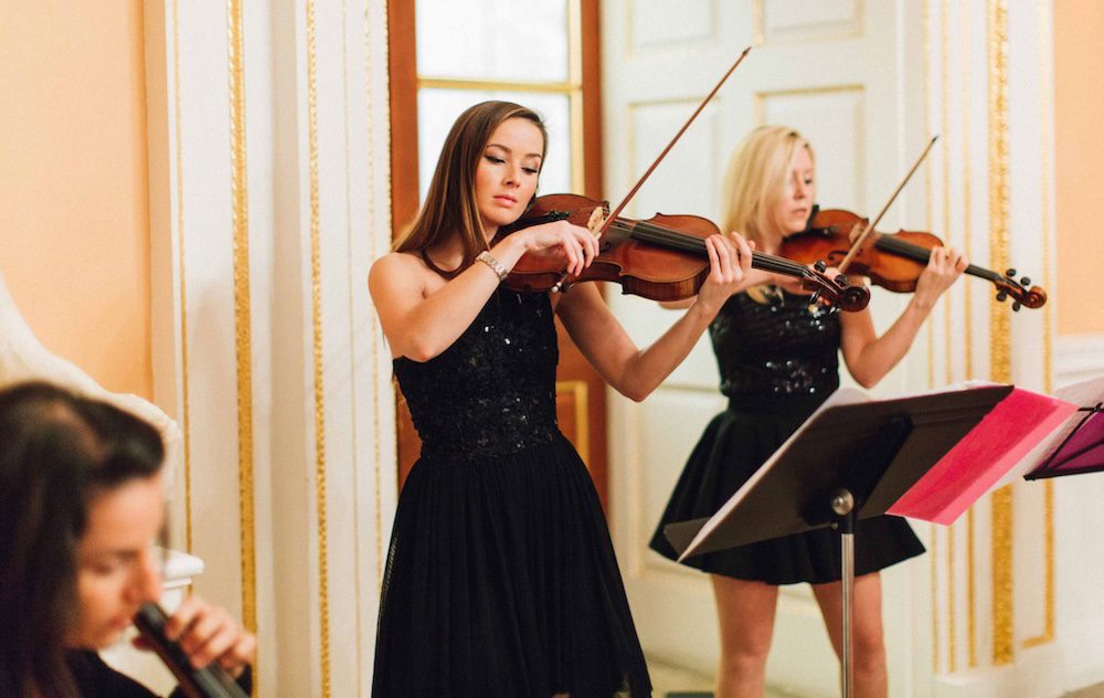 Secret Strings String Trio performing at a grand ballroom event